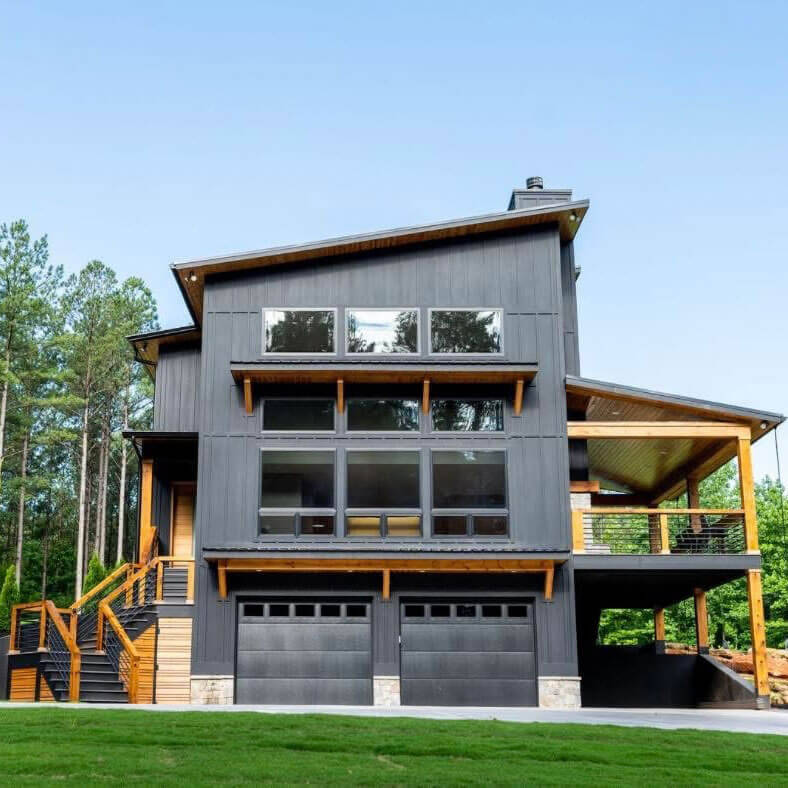 aerial photo of a custom, three-story home in the woods