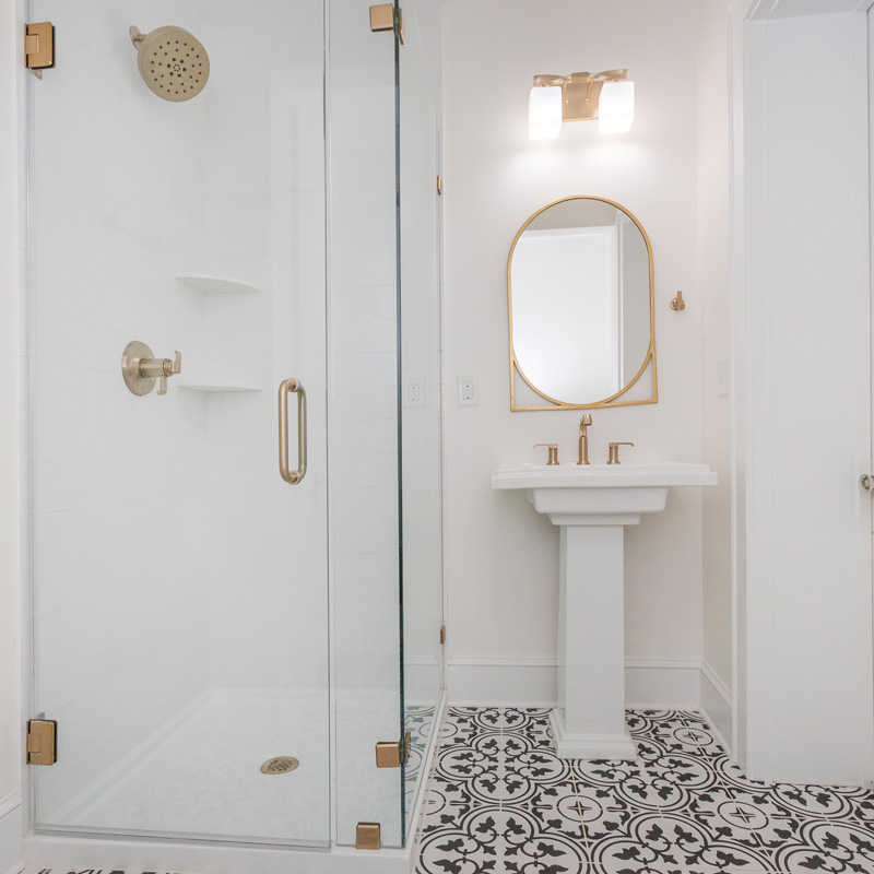 a shower with glass doors and pedestal sink