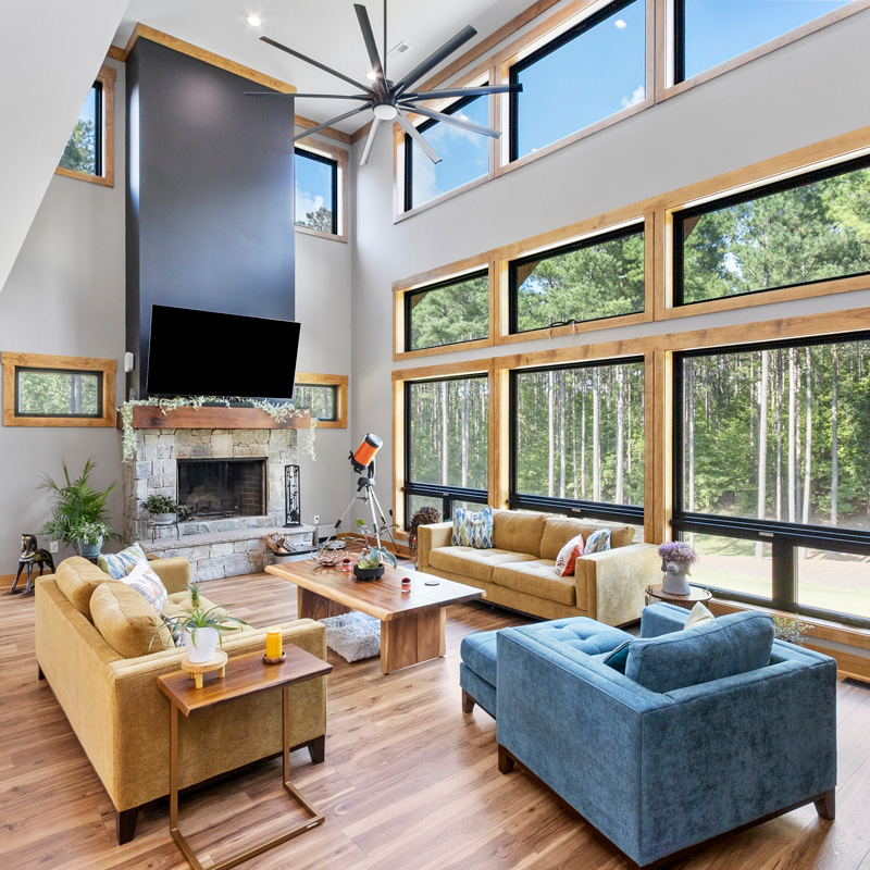 a living room area with large windows and fireplace