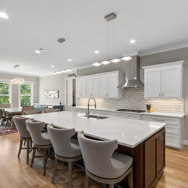 newly remodeled kitchen with white cabinets and an island with seating